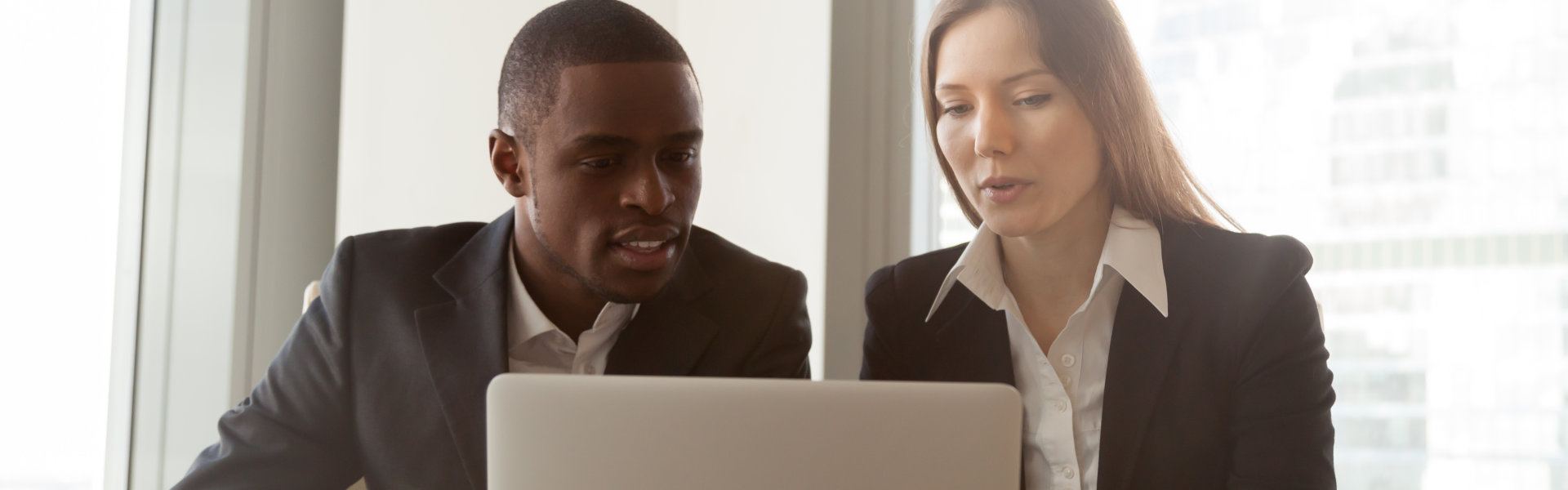 man and woman looking at the laptop
